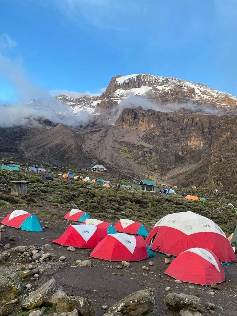 A dramatic view of the Umbwe Route on Mount Kilimanjaro, featuring steep trails surrounded by dense rainforest and towering cliffs.